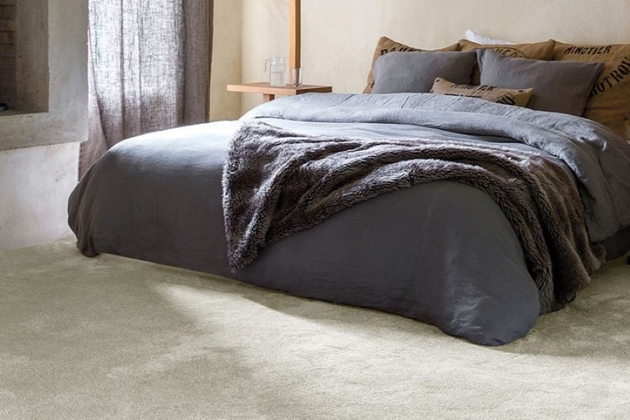 Cosy neutral bedroom with thick carpet and faux fur blanket on the bed